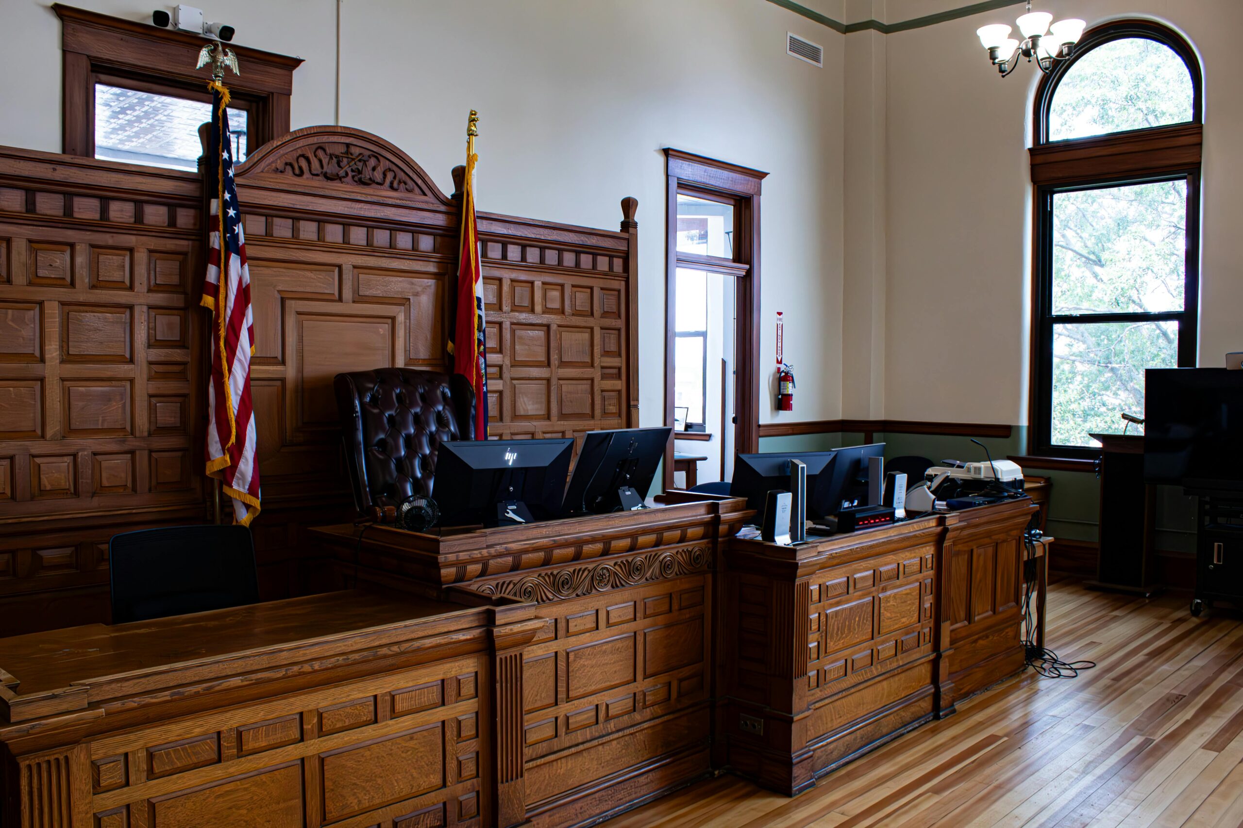 An empty judge and witness stand in the courtroom.